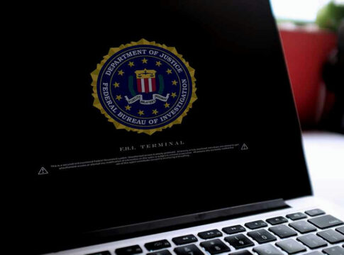 Laptop screen displaying FBI emblem and terminal interface.