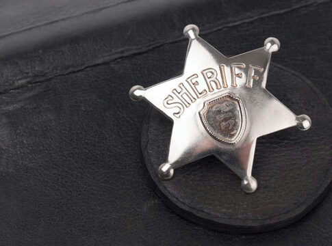 Sheriff badge on black leather surface.