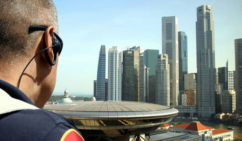 Security personnel overlooking a city skyline with modern skyscrapers