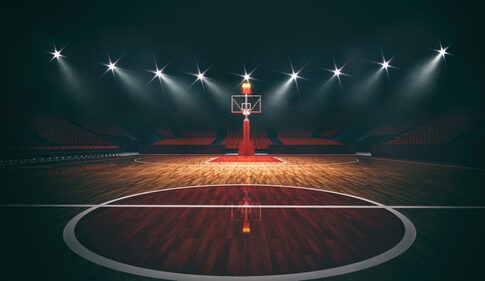 An empty basketball court illuminated by dramatic lighting